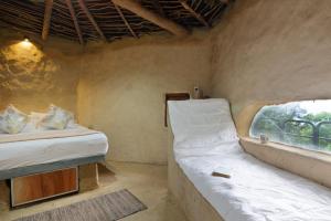 Voodi või voodid majutusasutuse Kithul cob hideaway toas