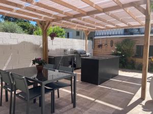 patio con tavolo e sedie sotto un pergolato in legno di 2 Bed apartment on the Dordogne River a Saint-Seurin-de-Prats