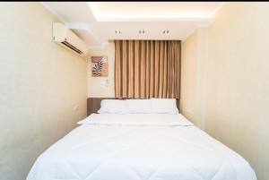 a small room with a bed with white sheets at Temple & Nile view in Luxor