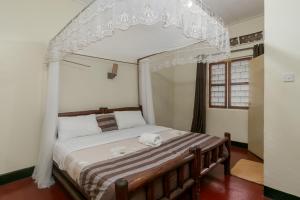 a bedroom with a bed with a canopy at Dream jet suites in Entebbe +131 photos