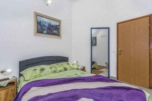 a bedroom with a bed with a purple blanket at Holiday home in Dolenja Vas - Istrien 51824 in Dolenja Vas