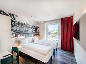 吕姆朗B&B HOTEL Zürich Airport的有两张床和一扇窗户的酒店房间