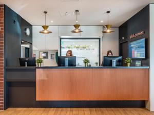 吕姆朗B&B HOTEL Zürich Airport的坐在候诊室柜台上的女人