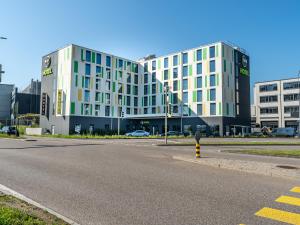 吕姆朗B&B HOTEL Zürich Airport的街道前有停车计的建筑物