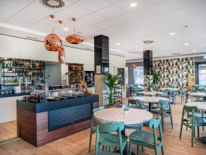 吕姆朗B&B HOTEL Zürich Airport的有桌椅和柜台的餐厅