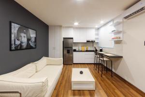a living room with a white couch and a kitchen at Silver Room Apartment in Santa Cruz de la Sierra
