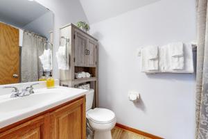 a bathroom with a white sink and a toilet at Knotty Pines in Wisconsin Dells +17 photos