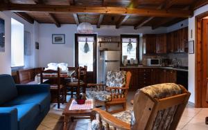 a living room with a blue couch and a kitchen at Case Gran Paradiso Rhemes Saint Georges in Rhemes-Saint-Georges