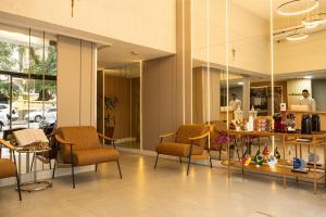 Un vestíbulo con sillas y una mesa en un edificio. en Hotel Nacional Inn Porto Alegre - Próximo ao Complexo Hospitalar Santa Casa e UFRGS, en Porto Alegre
