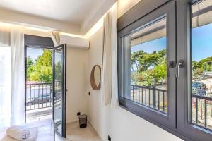 una camera da letto con una grande finestra e un balcone di Aegean View a Metamorfosi