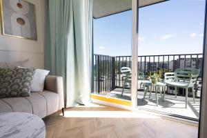 Una sala de estar con un sofá y un balcón. en Apartament GOLD DELUXE, en Gdansk