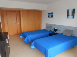 two beds in a room with blue sheets at Atlantico Apartments in Portimão +50 photos