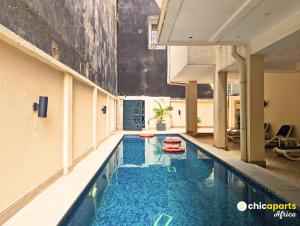 a swimming pool in a building with two red inflatable at Studio chic avec parking près de l'aéroport in Douala