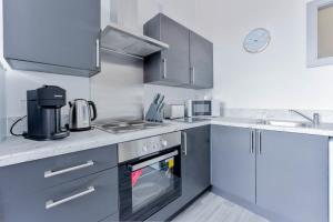 ダドリーにあるCosy & Bright 1 Bedroom Budget Apartment in Dudleyのコンロ付きのキッチン シンクの横にあるトップオーブン +3枚の写真