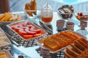 a table topped with different types of food on plates at Pousada Dunas da guarda in Guarda do Embaú