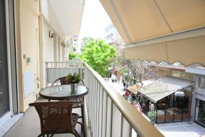 a balcony with a table and chairs and a street at White Luxury Apartments in Katerini
