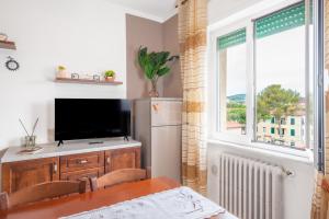 una cucina con tavolo, televisore e finestra di Piombino Apartments Casa Rossana a Piombino