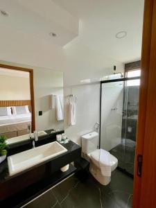 a bathroom with a toilet and a sink and a shower at Casa da Concordia in Vassouras +29 photos