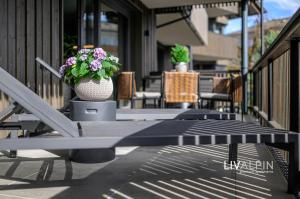 a bench on a porch with a pot of flowers at LIVALPIN Relaxe in Garmisch-Partenkirchen