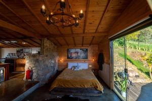 a bed in a room with a stone wall at Cabana Lobo Guará in Paiol Grande
