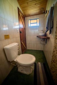 a small bathroom with a toilet and a sink at Cabana Lobo Guará in Paiol Grande
