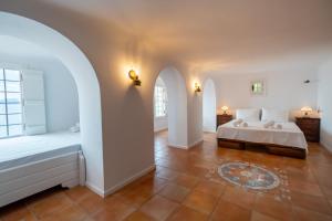 ein Schlafzimmer mit einem Bett und zwei Bögen in der Unterkunft The Wave Whisper in Volos