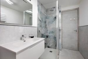 a white bathroom with a sink and a shower at perla in Aosta