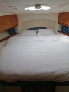 a large white bed in a small room at Motoryacht ELENA in Eeklo