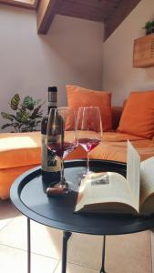 a table with a bottle of wine and two glasses at La Mansarda sotto il Castello in Magliano Alfieri