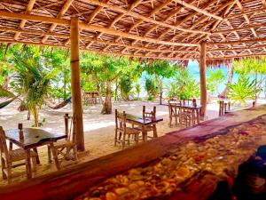 a group of tables and chairs in a restaurant at Dos Playa EcoCamp Daracoton Island in El Nido