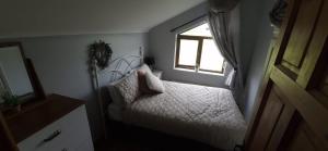 a small bedroom with a bed and a window at Gurrane House in Galway