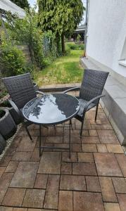 two chairs and a glass table on a patio at 2 Zimmer Ferienwohnung mit Terrasse in Ehlscheid