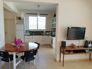 a kitchen and dining room with a table and a tv at Villa Oliva in Porto Heli