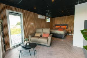 een slaapkamer met een bed, een bank en een tafel bij Garnwerd aan Zee in Garnwerd