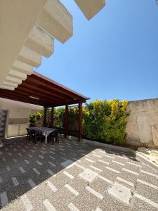 un patio con mesa y techo de madera en Casa Marpe by JDvacanze, en San Pietro in Bevagna