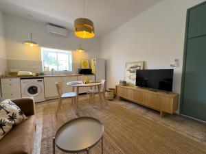 a living room with a couch and a tv and a table at Casa Limón Verde Tenerife in Güimar
