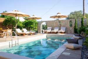 a swimming pool with chairs and umbrellas next to at Villa Terrestre in Lakithra
