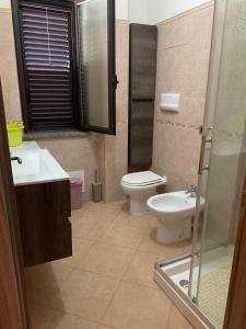 a bathroom with a toilet and a sink and a shower at Appartamento Fronte Mare Rosa 2 in Ardore Marina +14 photos