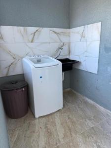 a washer and dryer in a corner of a bathroom at Pousada Vista da Serra, há 3min do Hospital Angelina Caron in Campina Grande do Sul