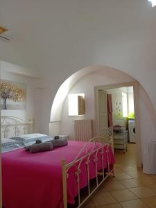 Un dormitorio con una cama con una manta rosa. en Trullo della Rosa, en Martina Franca