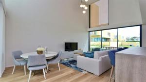 a living room with a couch and a table and chairs at Villa Rimah by Clever Details, central location, private pool can be heated in Quarteira
