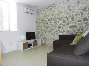 a living room with a couch and a stone wall at La Ferronnerie Cassis centre in Cassis