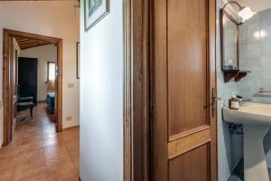 a bathroom with a sink and a wooden door at Casa Leccio relax con vista in Vinci