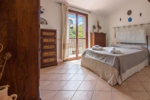 Un dormitorio con una cama y una ventana grande. en GuestHost - Comfy Apartment X3 with Terrace, en San Pantaleo