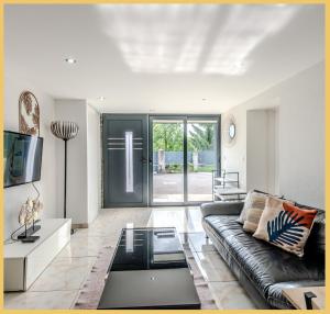 un salon avec un canapé et une table basse en verre dans l'établissement La Colline I T3 I Vétraz-Monthoux, à Vétraz-Monthoux