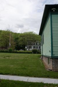 a green house with a yard next to a house at Hubbs Cellar at JS Hubbs Guest House in Hammondsport