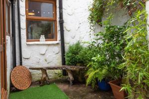 a bench sitting outside of a house with plants at Fisherman's Cottage by the sea in Morecambe