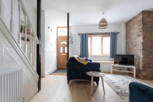 a living room with a blue couch and a tv at Fisherman's Cottage by the sea in Morecambe