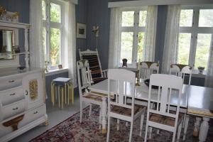 a dining room with a white table and chairs at Large house by nature reserve in Ystrebø