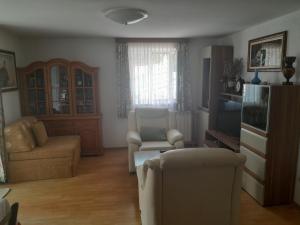 a living room with a couch and chairs and a tv at Apartments Jela in Splitska